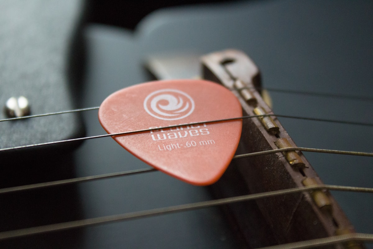 A Planet Waves guitar pick tucked between guitar strings